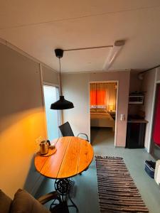 a living room with a wooden table in a room at Namiņš in Ragaciems