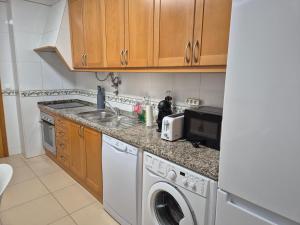 a kitchen with a washing machine and a sink at CARAVELL ARMAÇÃO de PÊRA in Armação de Pêra