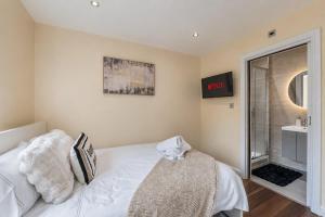a bedroom with a bed and a clock on the wall at Premium Apartment Steps from Wembley Park in London
