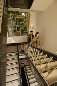 two men walking down a staircase in a building at Casa Malí by Dominion Boutique Hotel in Mexico City