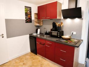 a kitchen with red cabinets and a counter top at Ferienwohnung Saupe in Königshain +15 photos