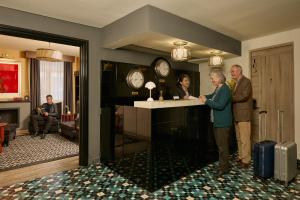 a man and a woman standing at a counter in a room at Casa Malí by Dominion Boutique Hotel in Mexico City