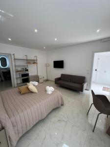a bedroom with a large bed and a couch at La dimora del duomo boutique suites & rooms in Terrasini