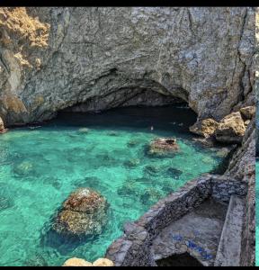 a pool of blue water with rocks in a cave at La dimora del duomo boutique suites & rooms in Terrasini