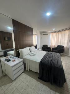 a bedroom with a large bed and a table at Hotel Victory flat in Cabedelo