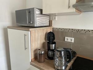 a kitchen counter with a microwave and a coffee maker at Apartament mit einem Schlafzimmer Ferienwohnung in Warendorf +27 photos