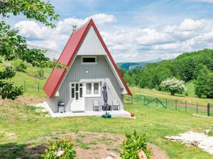 a small house with a red roof in a field at Cottage by the brook in Plužine