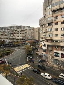 a city street with parked cars and tall buildings at Adrian Home Mega in Ploieşti