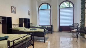 a room with two beds and two tables and two windows at Central Apartments Hof in Hof
