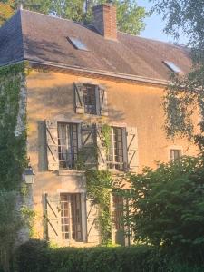 an old brick house with windows and a roof at la yourte du moulin in Champrond