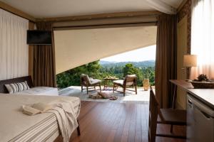 a bedroom with a view of a table and chairs at Mili Resort in Polychrono +72 photos