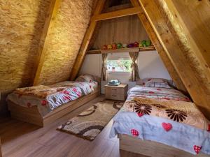 a attic bedroom with two beds and a window at Cottage by the brook in Plužine