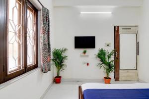a room with a bed and a tv on a wall at Hotel Elguse in kolkata