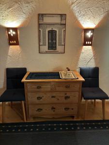 a room with a wooden dresser and two chairs at Haus Chiemseeblick in Grabenstätt