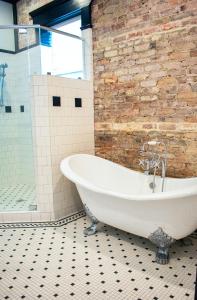 a bath tub in a bathroom with a brick wall at The Montgomery by Visit Apalach in Apalachicola +23 photos