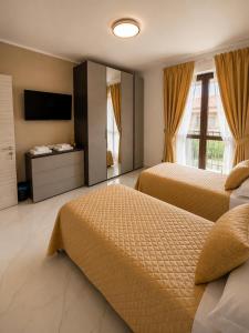 a hotel room with two beds and a television at Da Mario in Guarene +3 photos