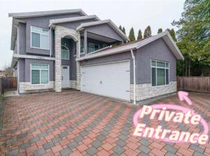 a house with a garage on a brick driveway at Si & Daniel Home Near YVR Airport & Skytrain Separate Entry Free Parking in Richmond
