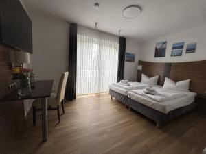 a bedroom with a bed and a table and a desk at Turmhotel Scharbeutz in Scharbeutz