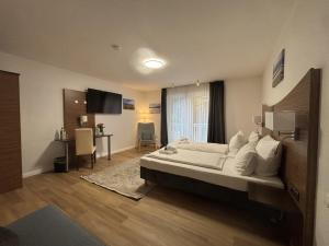a bedroom with a large bed and a desk at Turmhotel Scharbeutz in Scharbeutz