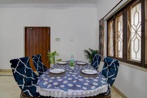a table with blue chairs and a blue and white table cloth at Hotel Elguse in kolkata