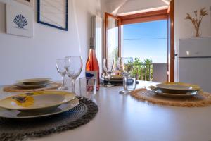 a table with plates and glasses and a bottle of wine at Altea in Fossacesia +23 photos