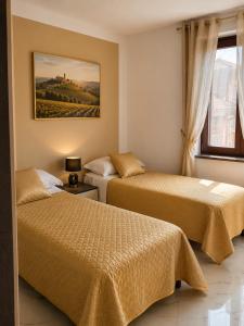 a bedroom with two beds and a window at Da Mario in Guarene