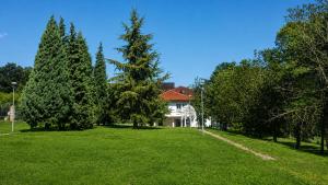a house in the middle of a field with trees at Hotel Radmilovac in Belgrade