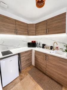 a kitchen with wooden cabinets and a white counter top at César Room - Appartement Antique 2-3 pers, parking privé,proche centre et gare in Obernai