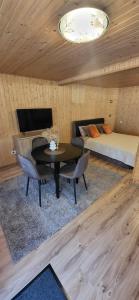 a room with a bed and a table and a couch at Sodyba pas Babą - Apartamentai SMILGIJA Šventoji in Palanga