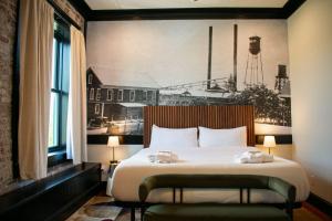 a bedroom with a large bed with a painting on the wall at The Montgomery by Visit Apalach in Apalachicola