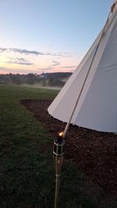 a close up of a white umbrella in a field at Teepee u Vlčího potoka in Jičíněves