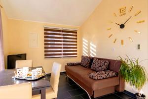 a living room with a couch and a clock on the wall at D&A Apartments in Vela Luka