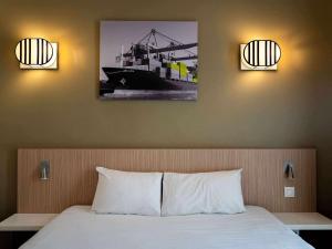 a bedroom with a bed with two lights above it at Aparthotel Adagio Access Le Havre Les Docks in Le Havre