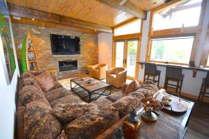 a living room with a large couch and a fireplace at Deer Lodge #2- Lake Front in Bass Lake +15 photos