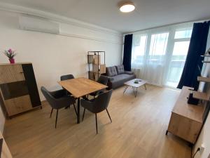 a living room with a table and chairs and a couch at Nagyerdő Naplemente Apartman Debrecen in Debrecen