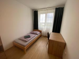 a small bedroom with a bed and a window at Nagyerdő Naplemente Apartman Debrecen in Debrecen