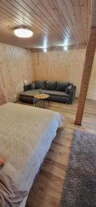 a living room with a bed and a couch at Sodyba pas Babą - Apartamentai SMILGIJA Šventoji in Palanga