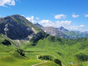 a green valley with a road in the mountains at Daheim Nr 2 - Südwesterhaus Allgäu in Oberstaufen