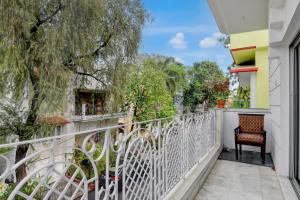 a balcony with a white fence and a chair at Hotel Elguse in kolkata