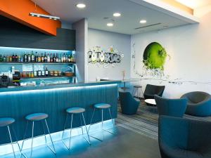 a bar in a restaurant with blue stools at ibis Styles Caen centre gare in Caen