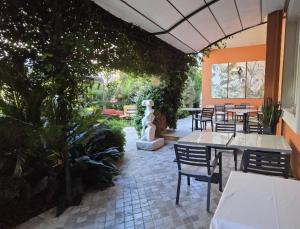 a patio with tables and chairs and plants at Hotel Viscardo in Forte dei Marmi +37 photos