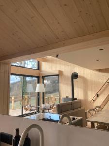 a kitchen with a sink and a living room at Le Chalet Cormoyeux in Cormoyeux