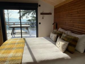 a bedroom with a bed with a view of a patio at Le Chalet Cormoyeux in Cormoyeux