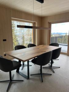 a dining room with a wooden table and chairs at Das Zehnerkar Chalet - Klippitztörl in Kliening