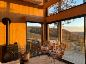 a large screened in porch with a fireplace and chairs at Le Chalet Cormoyeux in Cormoyeux