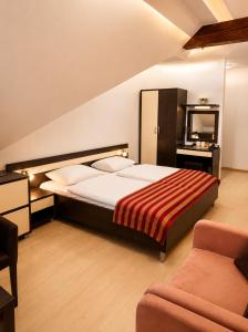 a bedroom with a bed and a tv and a couch at Komnata Bešeňová - Apartmán 344 in Bešeňová +60 photos