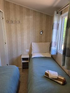 a small bedroom with a bed and a window at 2 bedrooms caravan with a sea view in Poole