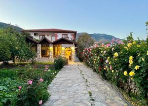 a house with a garden of flowers in front of it at Melinda Pension & Restaurant in Mesudiye