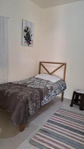 a bed sitting in a room with a rug at Katty House in Santa Bárbara de Samaná