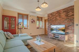 a living room with a couch and a brick wall at Vila Trate with Shared Pool and Garden in Ljutomer